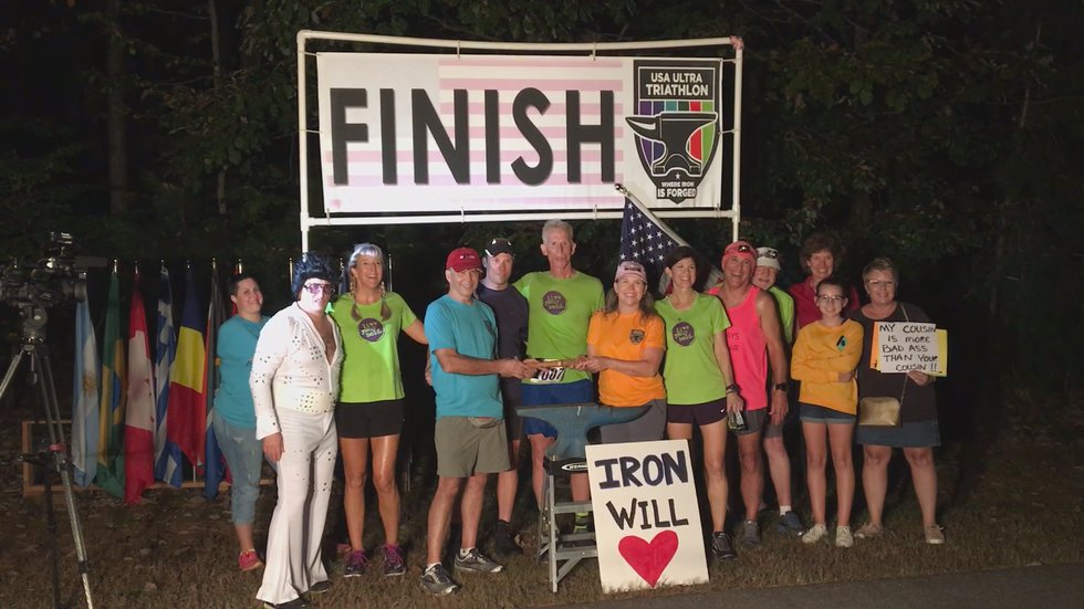 Turner celebrating 45th Ironman race surrounded by support group.