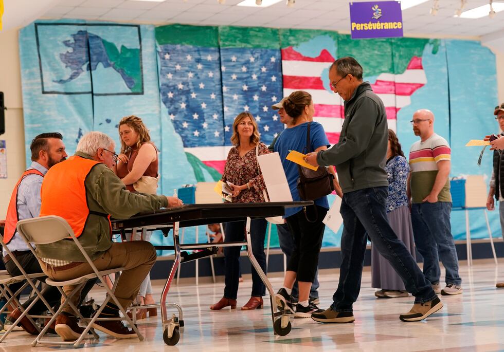 People line up to vote in front of a mural at a Elementary school polling station Tuesday Nov....