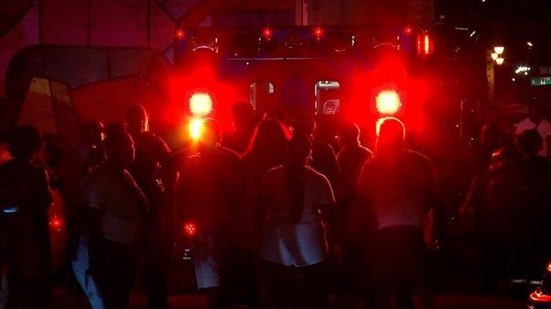 Club-goers crowd around an ambulance where a stabbing victim is being treated. (Source: NBC12)