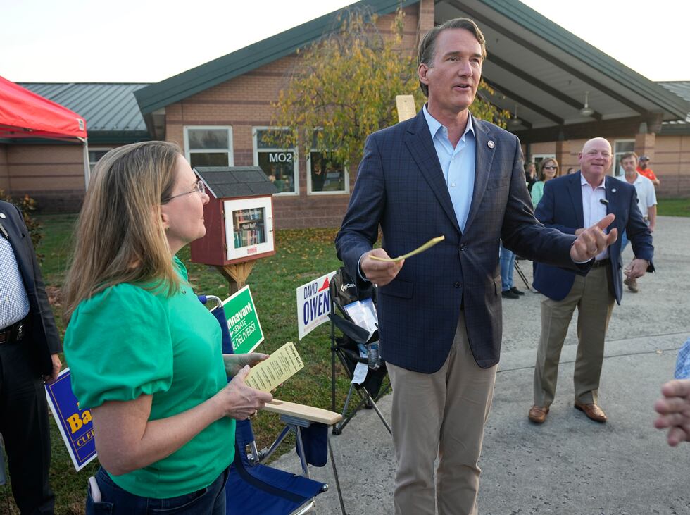 Virginia Gov. Glenn Youngkin, right, hands out sample ballots along with Virginia State Sen....