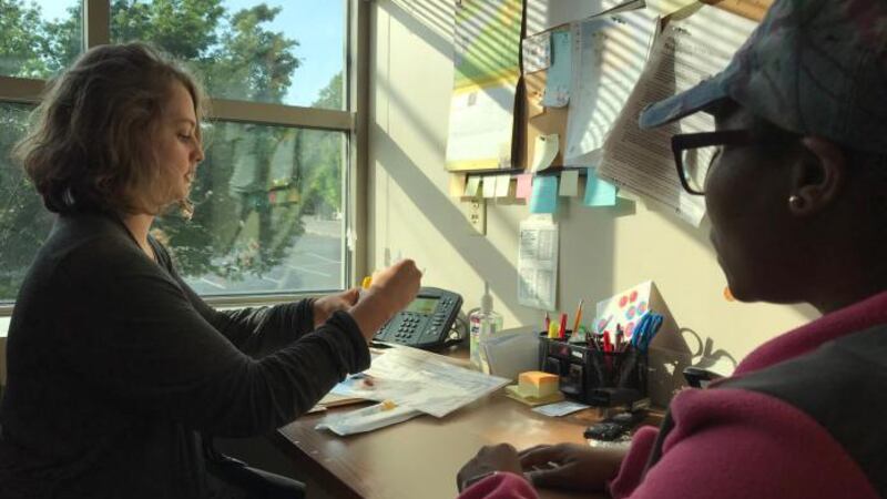 Emily Cadden, a health educator at Richmond City Health District, demonstrates to a patient...
