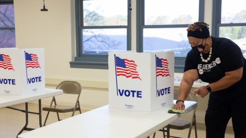 An election official wipes down a table after every voter in Buckingham County, Nov. 3, 2020.