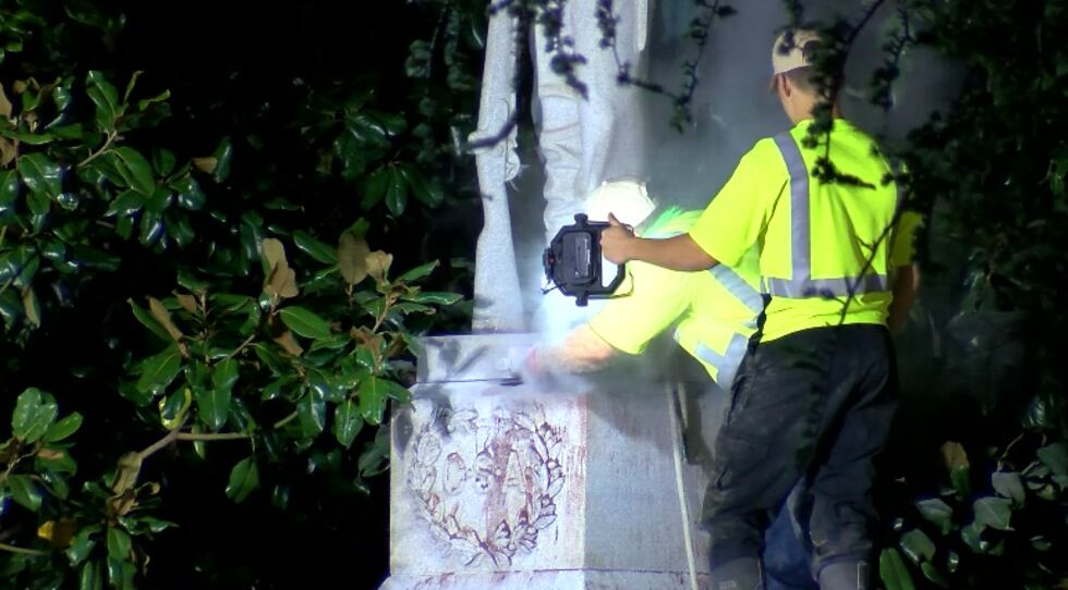 Workers remove the Confederate soldier statue from the Madison County Courthouse