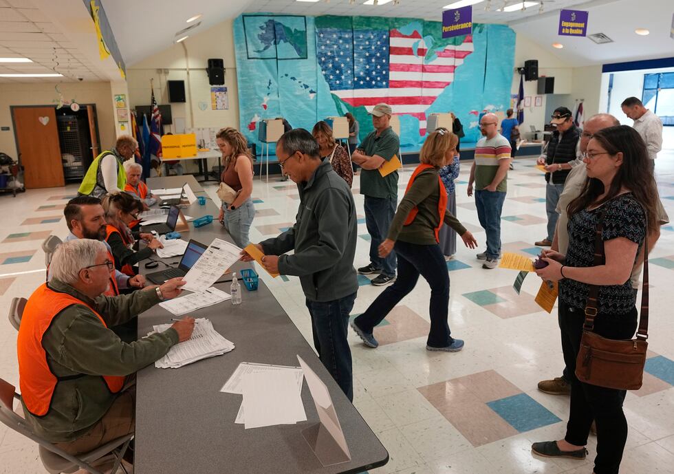 People line up to vote in front of a mural at a Elementary school polling station Tuesday Nov....