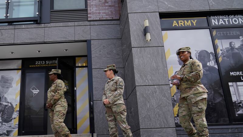 FILE - The U.S. Army National Guard members stand outside the Army National Guard office...