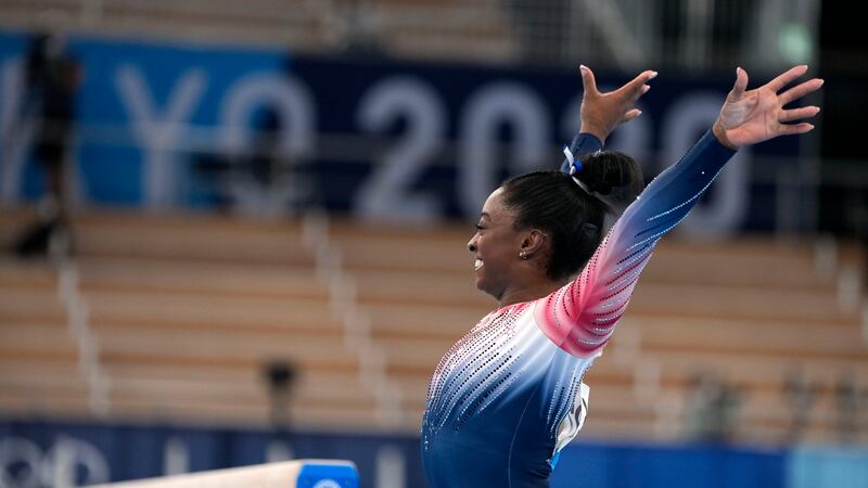 Simone Biles, of the United States, dismounts from the balance beam during the artistic...