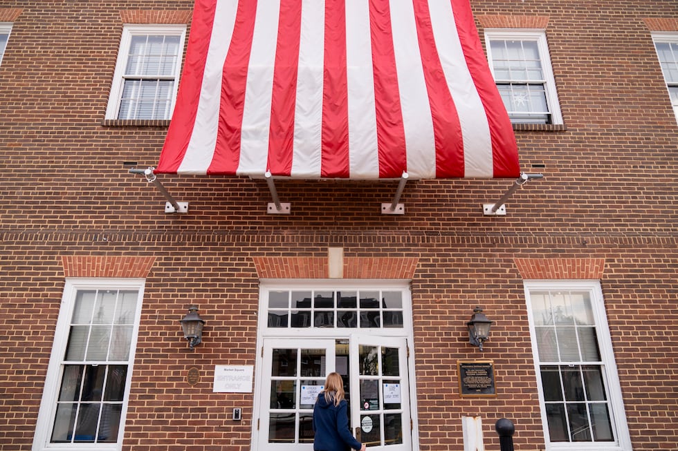 A woman enters a voting polling place at Alexandria City Hall, in Alexandria, Va., Tuesday,...