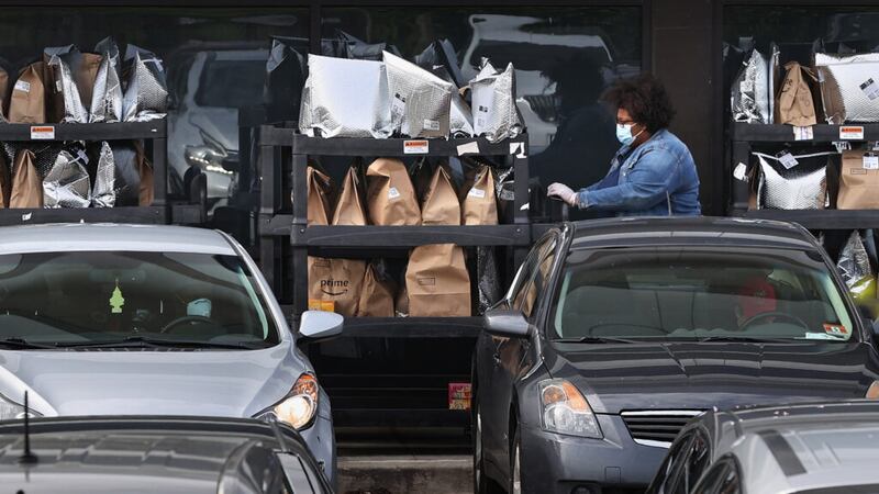 An Amazon Flex driver loads their personal vehicle with packages outside an Amazon fulfillment...